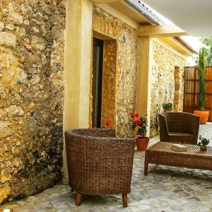 a patio with two chairs and a table and a stone wall at CASA ANDORINHAS in Fontainhas
