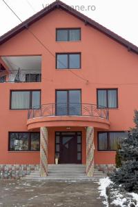 an orange building with a balcony and stairs at Vila Sanne Brașov , Hălchiu in Heldsdorf