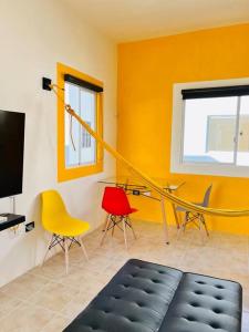 a living room with a tv and chairs at El mirador de Los Sauces in Puerto Vallarta