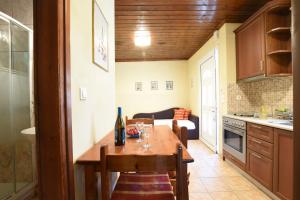 a kitchen with a table with wine glasses on it at Haus Platanos Apartments & Bungalows by the Sea in Vourvourou