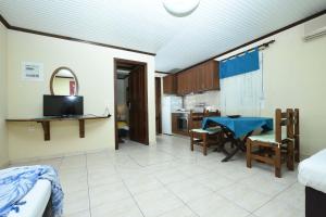 a living room with a table and a kitchen at Haus Platanos Apartments & Bungalows by the Sea in Vourvourou