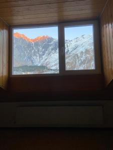 una finestra in una camera con vista su una montagna di Mansarda Kazbegi a Kazbegi