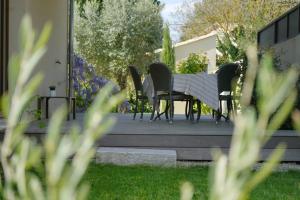 a table and chairs sitting on a porch at La Maison de l'Yle - Villa avec piscine in L'Isle-sur-la-Sorgue