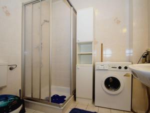 een badkamer met een douche en een wasmachine bij Apartment, Dornumersiel in Dornumersiel