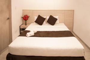 ein Schlafzimmer mit einem großen Bett mit zwei Kissen in der Unterkunft Hotel Bestmark Platino in Bogotá