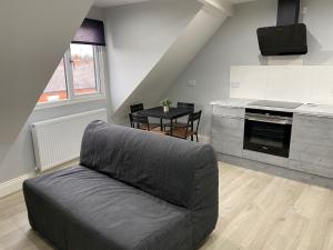 een woonkamer met een bank en een keuken bij Stunning property fully refurbished in Birmingham