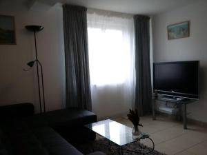 een woonkamer met een bank en een flatscreen-tv bij Appart 53 m2 en Rdc maison, jardin, à 50 m plage in La Turballe