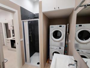 a bathroom with two washing machines and a washer and dryer at Bilocale incantevole a Barletta - Puglia in Barletta