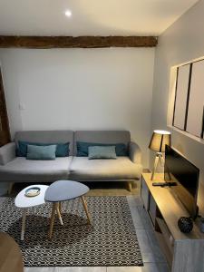 ein Wohnzimmer mit einem Sofa und einem Tisch in der Unterkunft Joli appartement quartier historique in Moulins