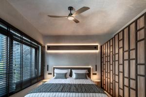 1 dormitorio con 1 cama y ventilador de techo en Ardor Exclusive Villas, en Vourvoúlos