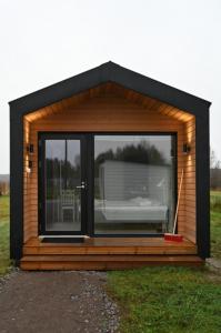 a small cabin with a large window in a field at Willa Rauha 1B in Lumijoki