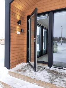 una puerta abierta en el lateral de una casa en Willa Rauha 1B, en Lumijoki