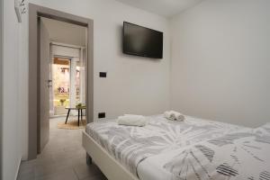 a bedroom with a bed and a television on the wall at Apartments Elena Tia in Medulin