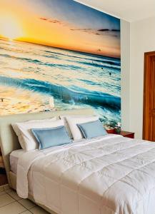 1 dormitorio con 1 cama y una pintura del océano en Ouranos Studios, en Kalamaki