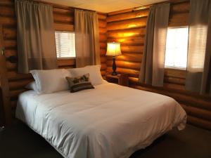 1 dormitorio con cama blanca y ventana en Sportsman's Lodge, en Ennis