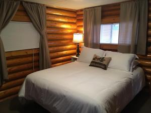 um quarto com uma cama branca e uma janela em Sportsman's Lodge em Ennis