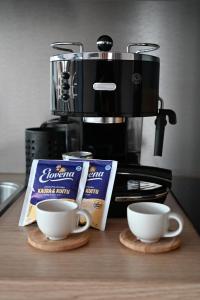 una macchinetta del caffè e due tazze su un bancone di Willa Rauha 1B a Lumijoki