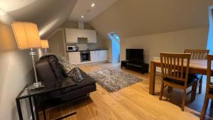 a living room with a couch and a dining room table at NEW 1BD Contemporary Flat Upper Dunblane in Dunblane