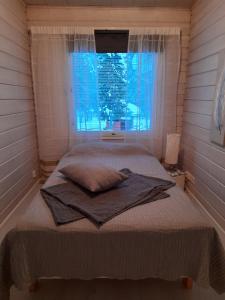 a bed in a room with a window with a blanket at Villa Wältti in Rovaniemi