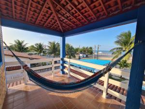 a hammock on the porch of a house with a pool at Blue House - Lucena in Lucena