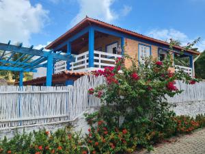een huis met een wit hek en bloemen bij Blue House - Lucena in Lucena