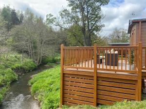 une grande terrasse en bois à côté d'une rivière dans l'établissement Carre Retreat with private hot tub, à Felton