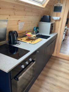 a kitchen with a stove and a counter top at Robins Nest Glamping Pod with Hot Tub in Keith