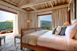 a bedroom with a bed and a large window at Kahani Paradise in Gokarna
