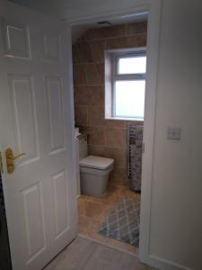 a bathroom with a toilet and a window at Peaceful time in Trowbridge
