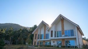 a house with a mountain in the background at The Viewpoint House in Namhae