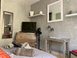 um quarto com uma cama, uma televisão e uma mesa em Villa fiora chambre em Martigues