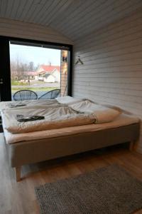 Willa Rauha E في Lumijoki: سرير في غرفة مع نافذة كبيرة