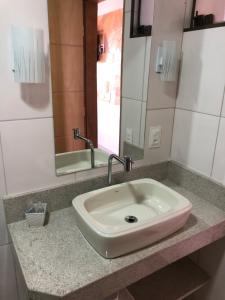 a white sink in a bathroom with a mirror at Pousada Pedra Encantada in São Thomé das Letras +39 photos