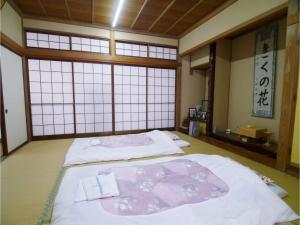 two beds in a room with two windows at T-Port hayahoshi - Vacation STAY 12340 in Toyama