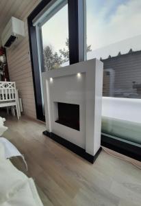 Willa Rauha E في Lumijoki: مدفأة بيضاء في غرفة بها نافذة