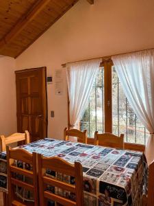 1 dormitorio con mesa con sillas y ventana en CABAÑAS MANOLO en San Carlos de Bariloche
