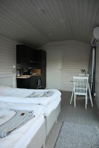 a bedroom with two beds and a table and a chair at Willa Rauha E in Lumijoki
