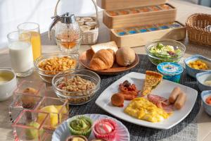 a table topped with plates of breakfast foods and drinks at Hotel Keihan Sendai in Sendai