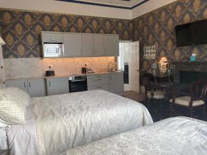 a bedroom with a bed and a kitchen with a desk at Pulteney House in Bath