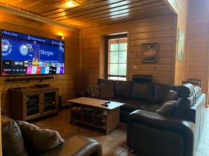 salon z kanapą i telewizorem z płaskim ekranem w obiekcie Pensjonat Danielka w mieście Ujsoły