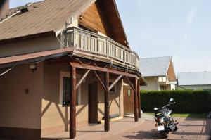 a motorcycle parked in front of a house with a balcony at PRIVAT FAMILY MALA FATRA in Chmelince
