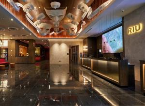 a lobby of a hotel with a television and masks on the ceiling at Riu Plaza Manhattan Times Square in New York