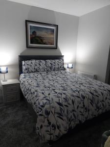 1 dormitorio con 1 cama y una foto en la pared en Portstewart Atlantic Cove Hatheran Gardens, en Portstewart