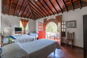 um quarto com 2 camas, uma mesa e uma cadeira em Hotel San Gil Campestre em San Gil