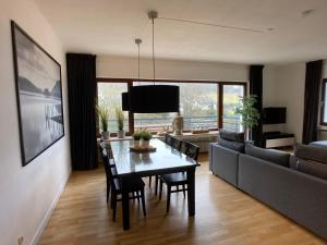 sala de estar con mesa de comedor y sofá en Villa Holgenbach - Penthouse- und Ferienwohnung im Nationalpark Eifel, en Schleiden