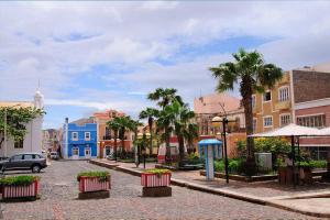 a city street with colorful buildings and palm trees at Samara's Home in Mindelo