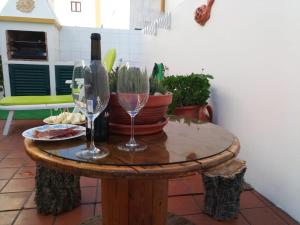 stół z 2 kieliszkami i butelką wina w obiekcie Silva's House w mieście Vila Nova de Milfontes