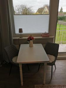 un tavolo con due sedie e un vaso con dei fiori sopra di Baltic30 a Krien
