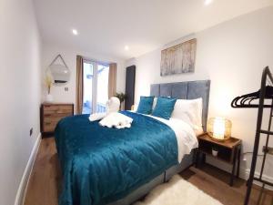 a bedroom with a large bed with a blue blanket at Luxury pad centrally located near Brighton station in Brighton & Hove