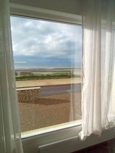 ein Fenster mit Blick auf den Strand in der Unterkunft Côté Mer in Barneville-Carteret
